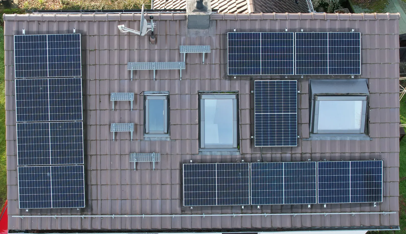 Solarmodule auf einem Frankfurter Hausdach, angeordnet um drei Dachfenster