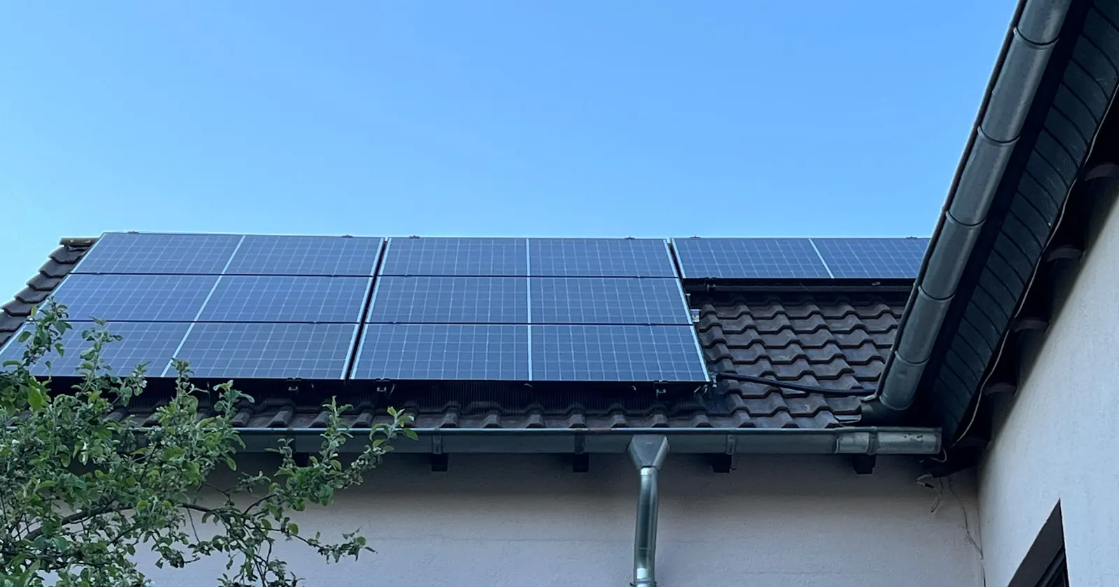 Solarmodule über der Dachrinne eines Wohnhauses